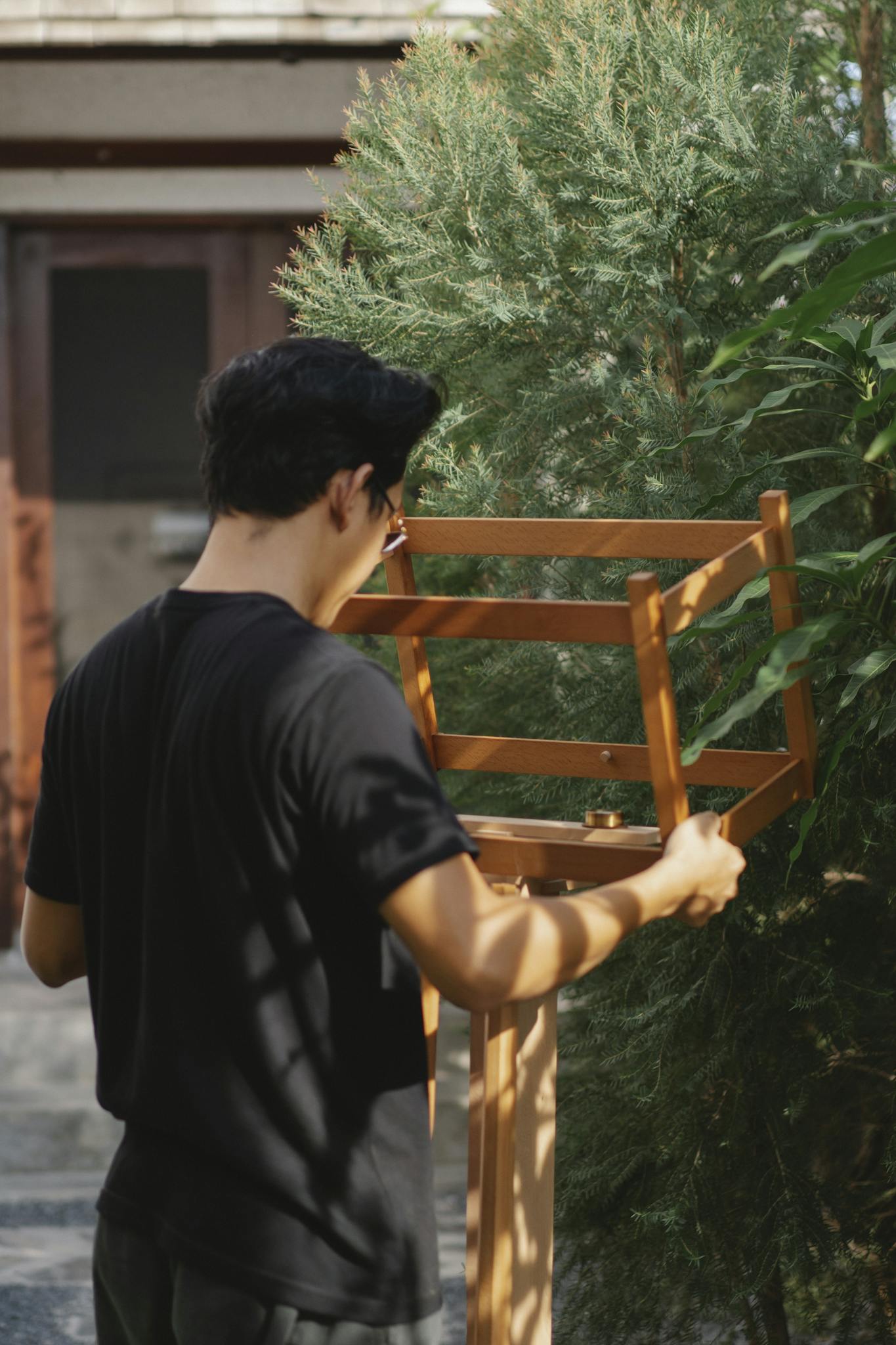 Man engaged in DIY carpentry project in sunny backyard.